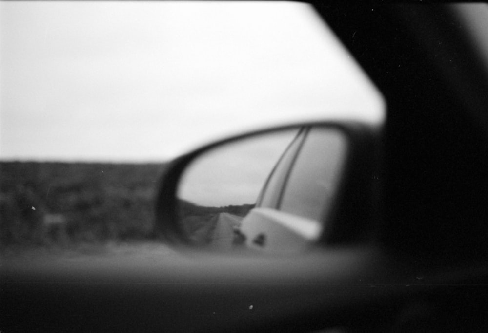a car's side view mirror is shown in black and white
