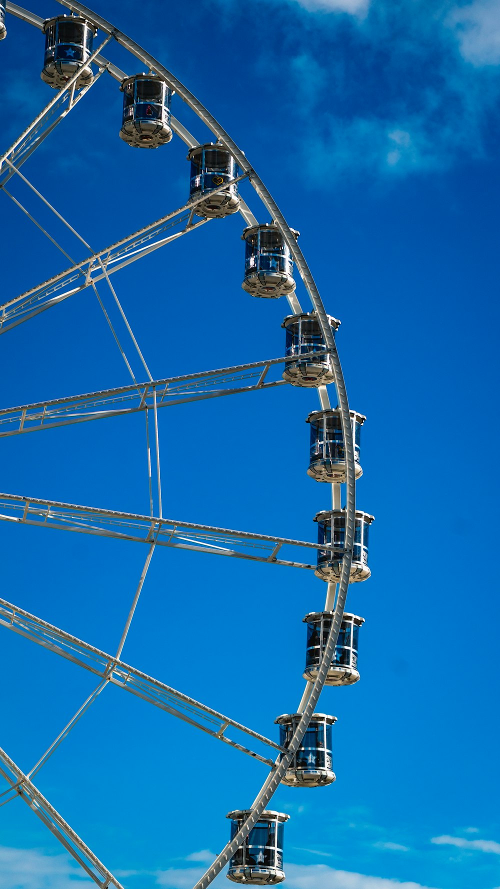 a ferris wheel against a blue sky with clouds