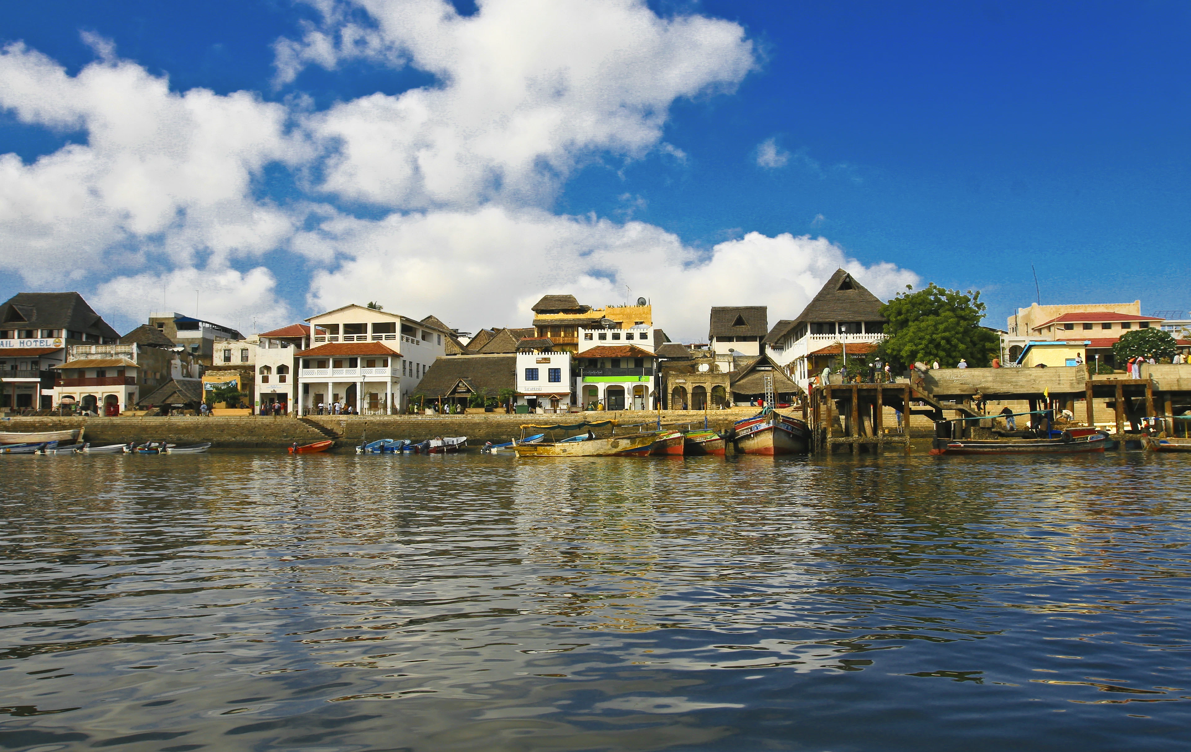 Lamu miesto krantinė su baltais namais ir valtimis, Kenija