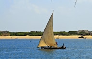 a sailboat with two people on it in the water
