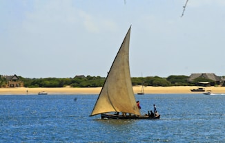 a sailboat with two people on it in the water