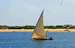 a sailboat with two people on it in the water