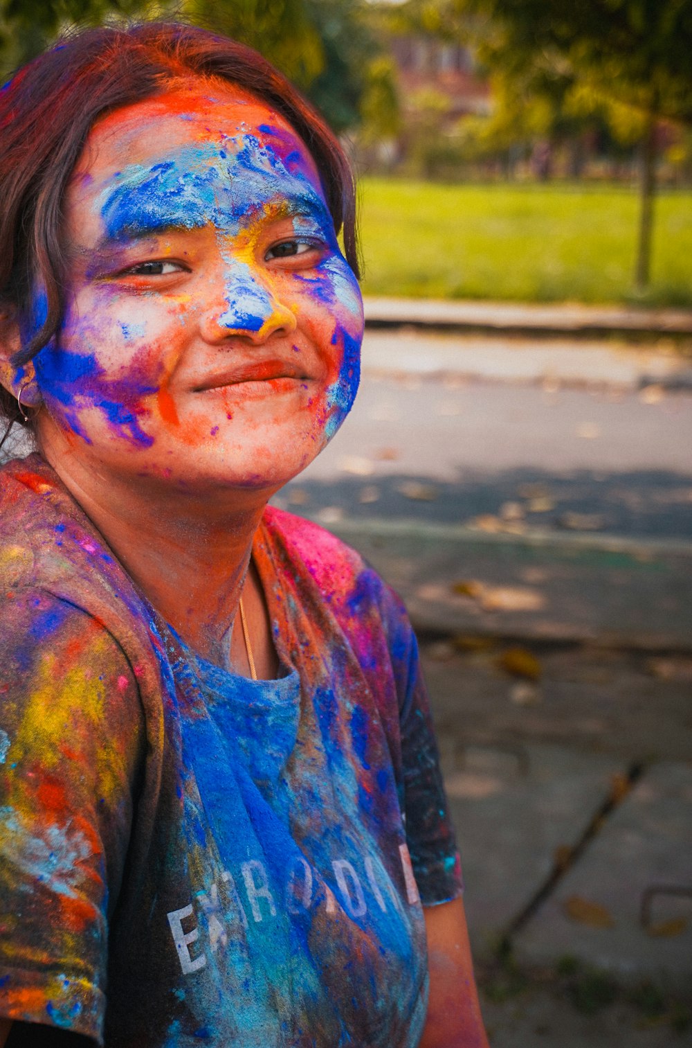 a young girl is covered in colorful paint