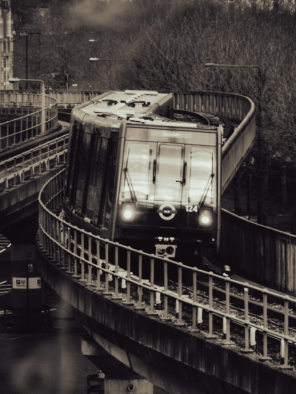 a black and white photo of a train going over a bridge