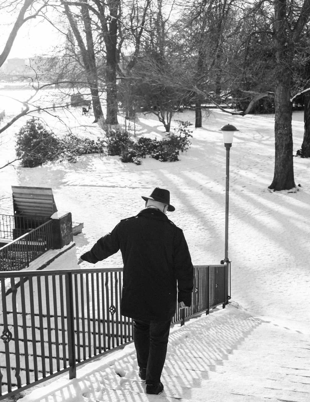 a man walking down a snow covered sidewalk