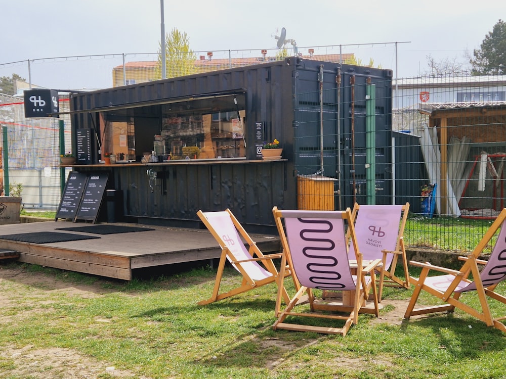 a group of lawn chairs sitting in front of a shipping container