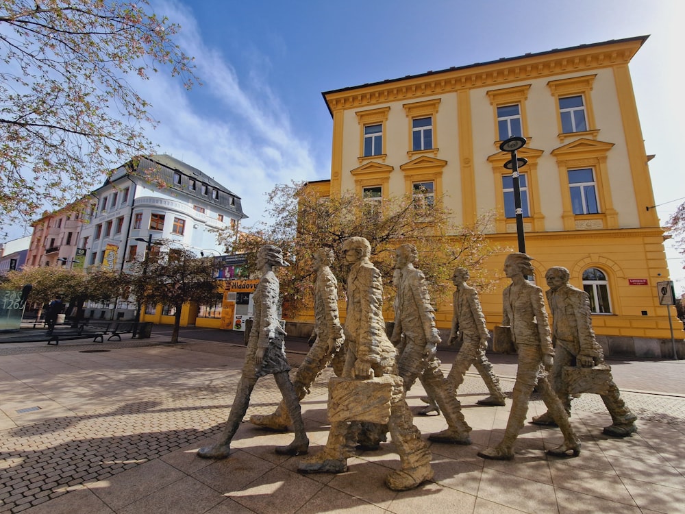 a statue of a group of people in front of a building