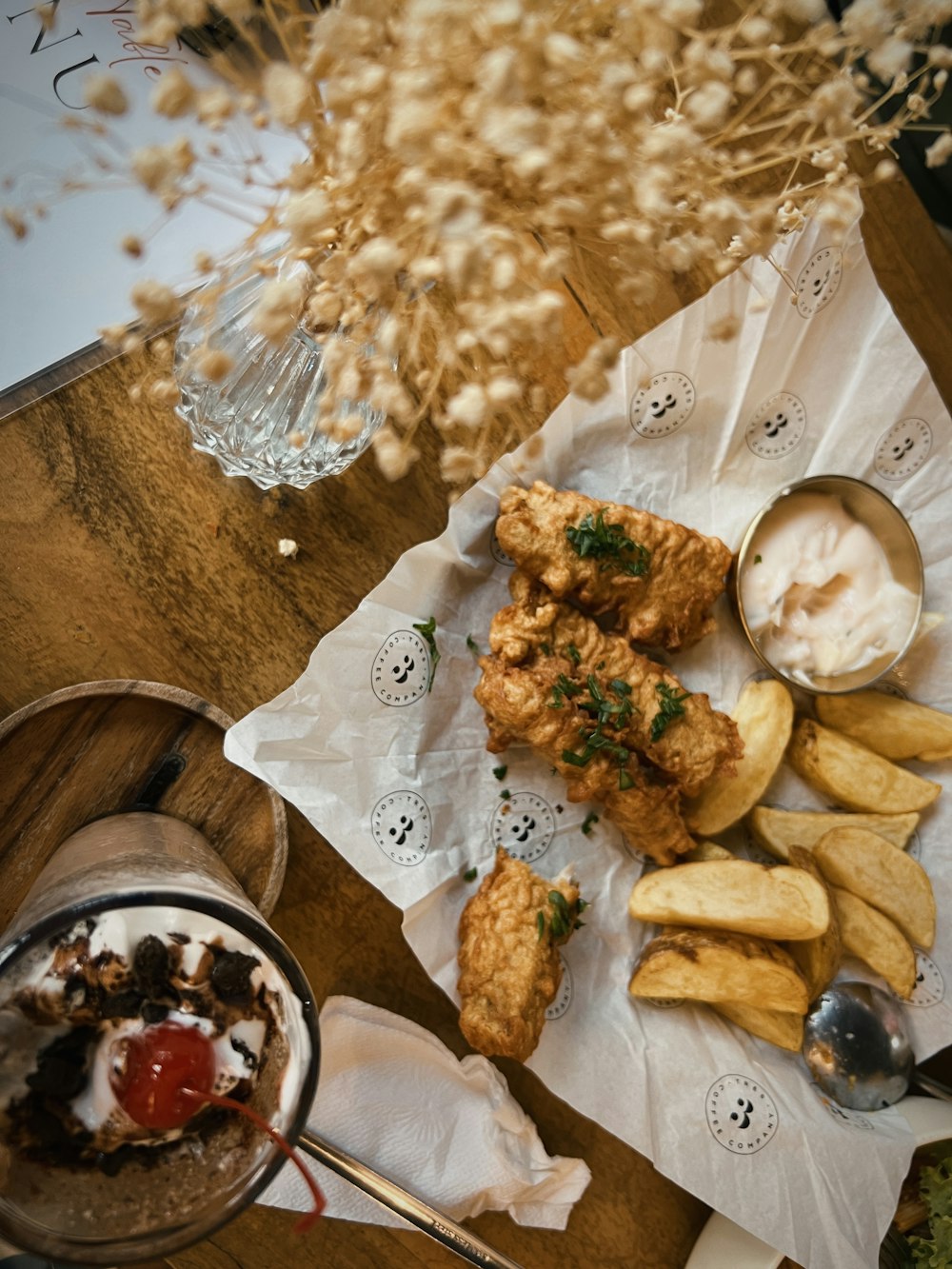 a wooden table topped with fried food and french fries