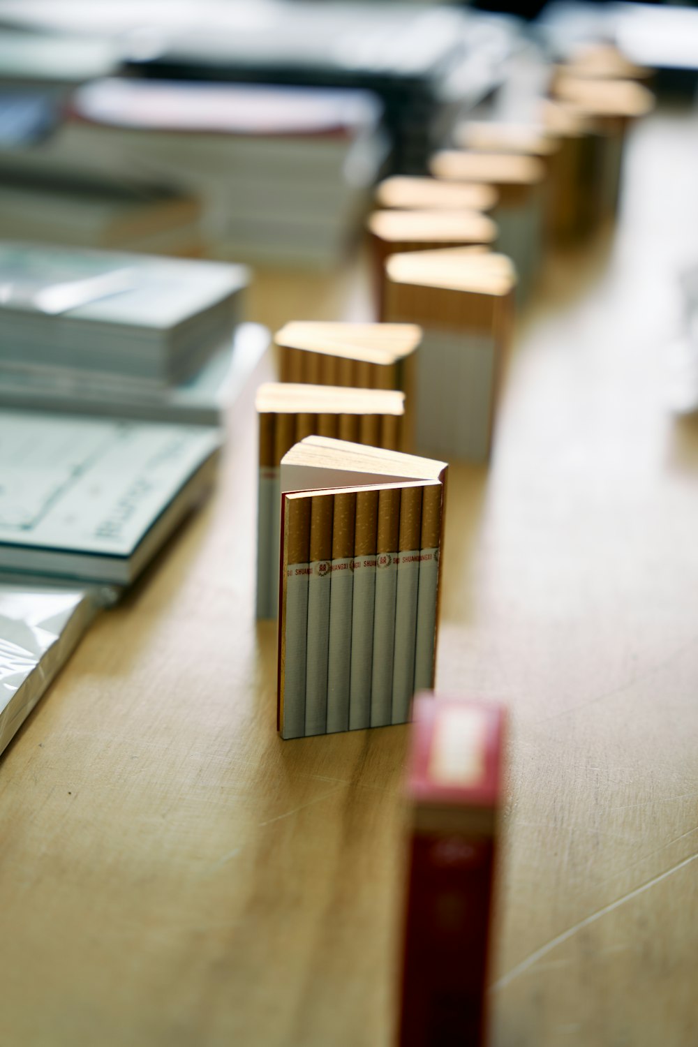 a row of cigarettes sitting on top of a wooden table