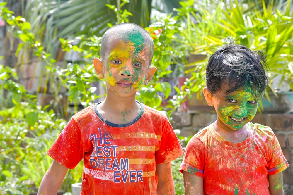 two young boys covered in paint standing next to each other