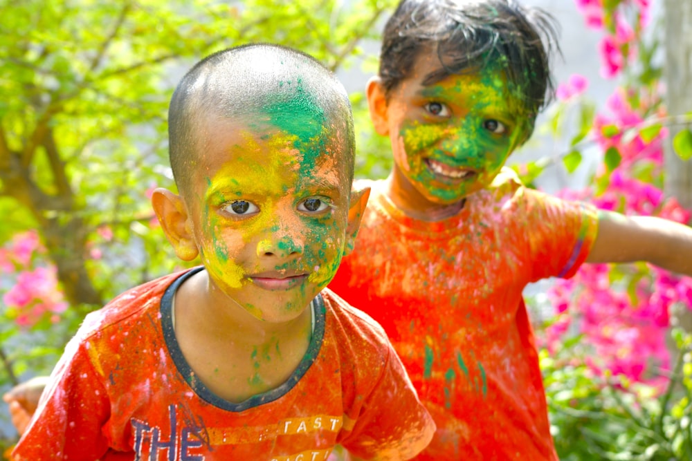 two young boys covered in paint posing for a picture