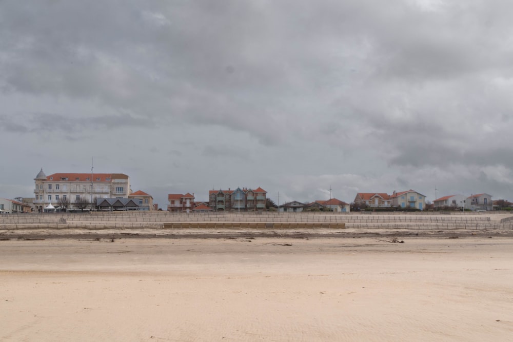 une plage de sable avec des maisons au loin