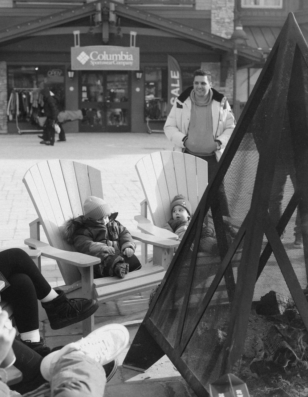 a black and white photo of people sitting in chairs