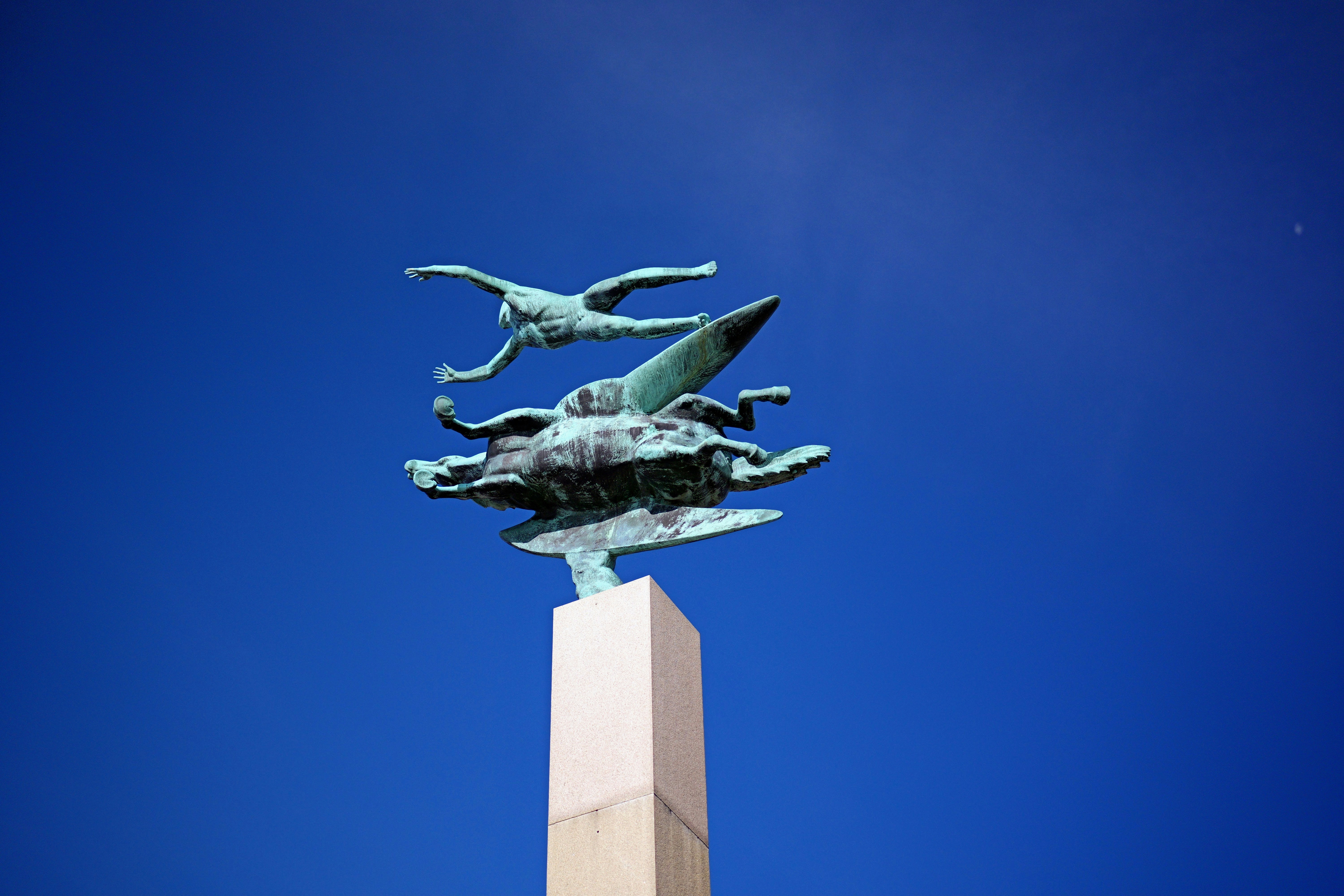 a statue on top of a tall white pillar