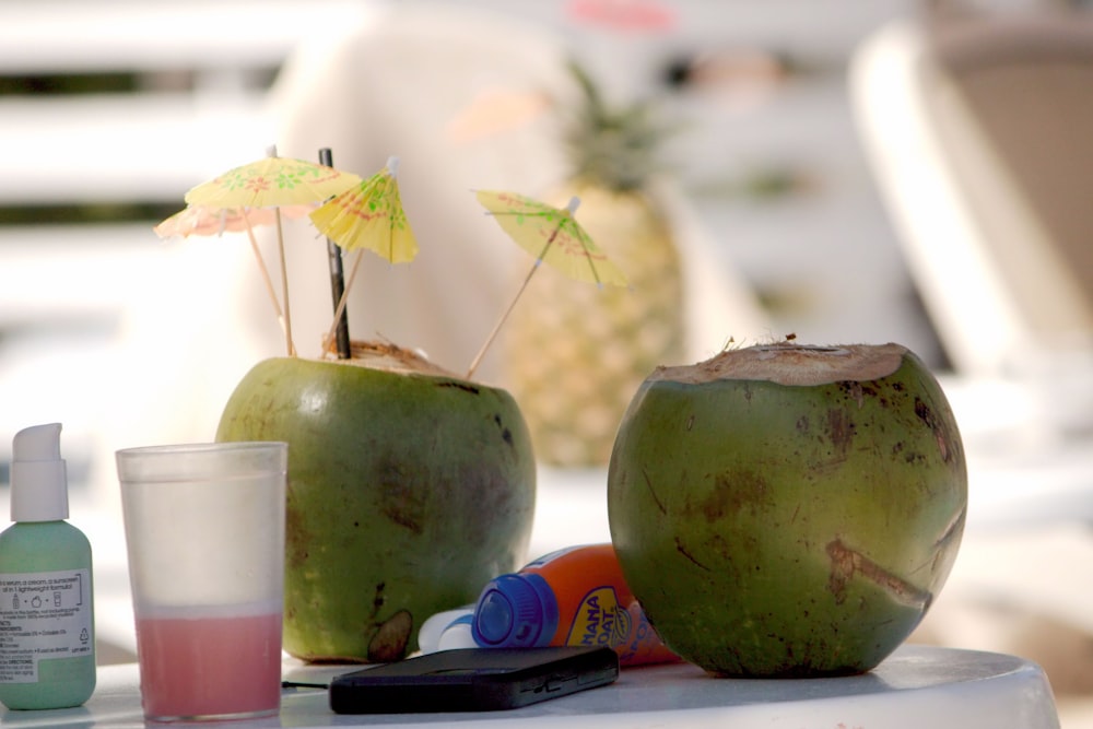 a couple of green coconuts sitting on top of a table