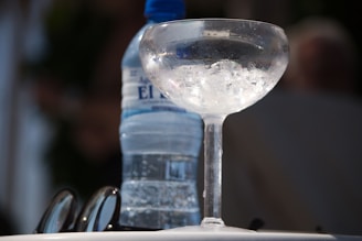 a glass of water and a bottle of water on a table