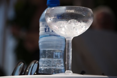 a glass of water and a bottle of water on a table