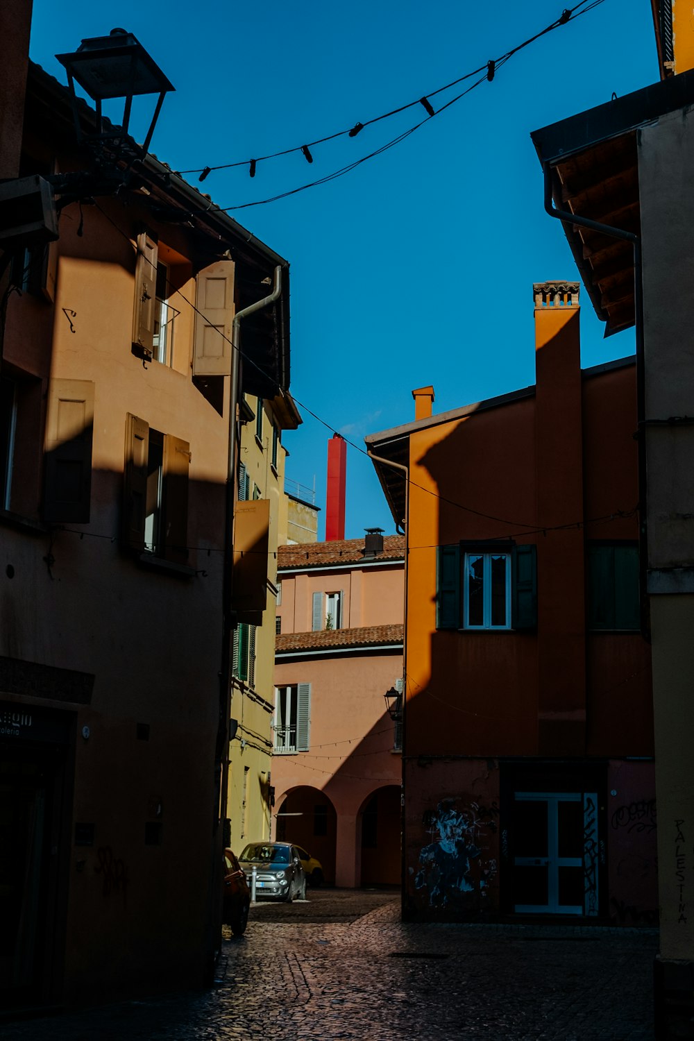 una calle con edificios y una torre del reloj a lo lejos