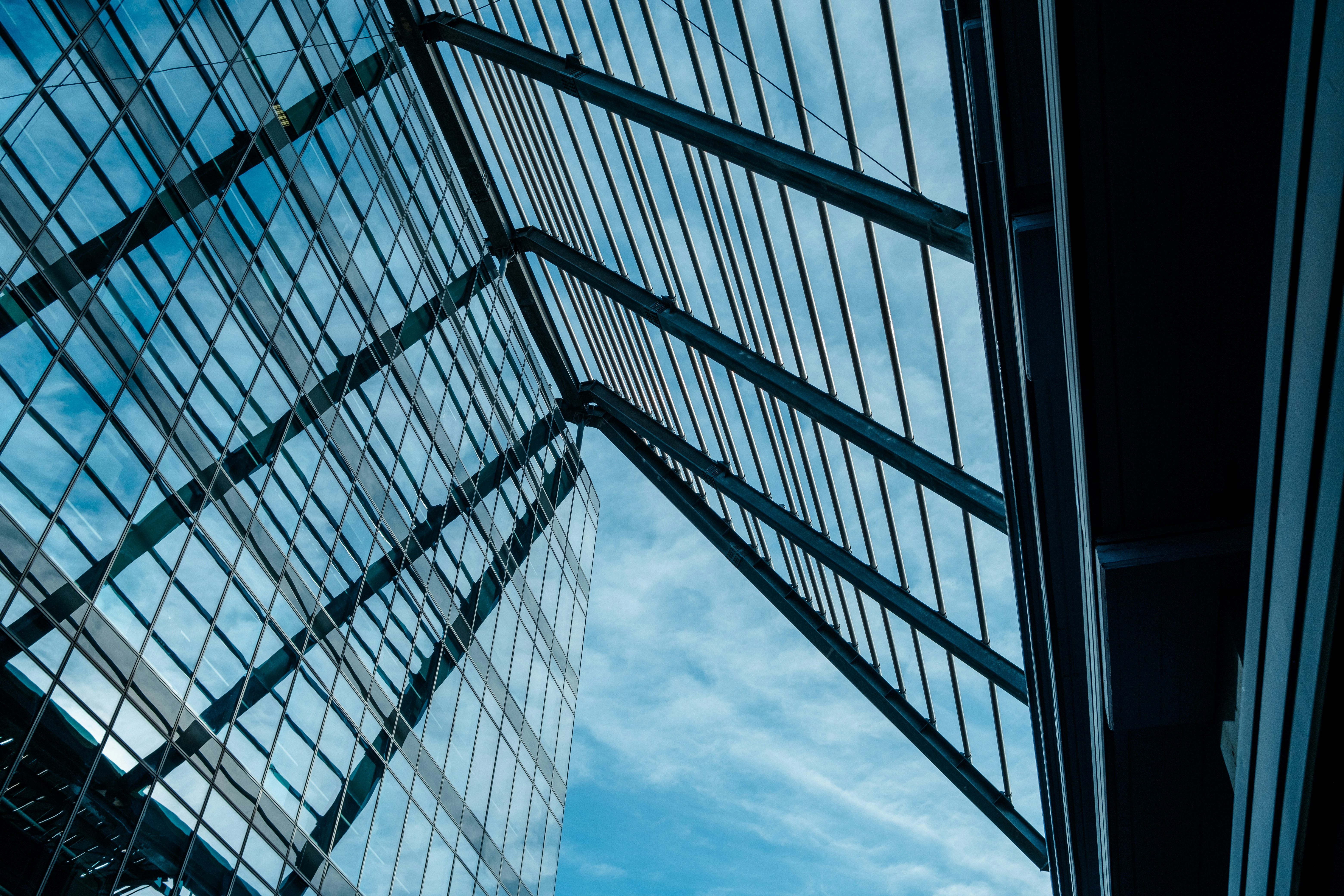 Glass skyscraper reflecting blue sky, modern commercial architecture, steel and glass facade