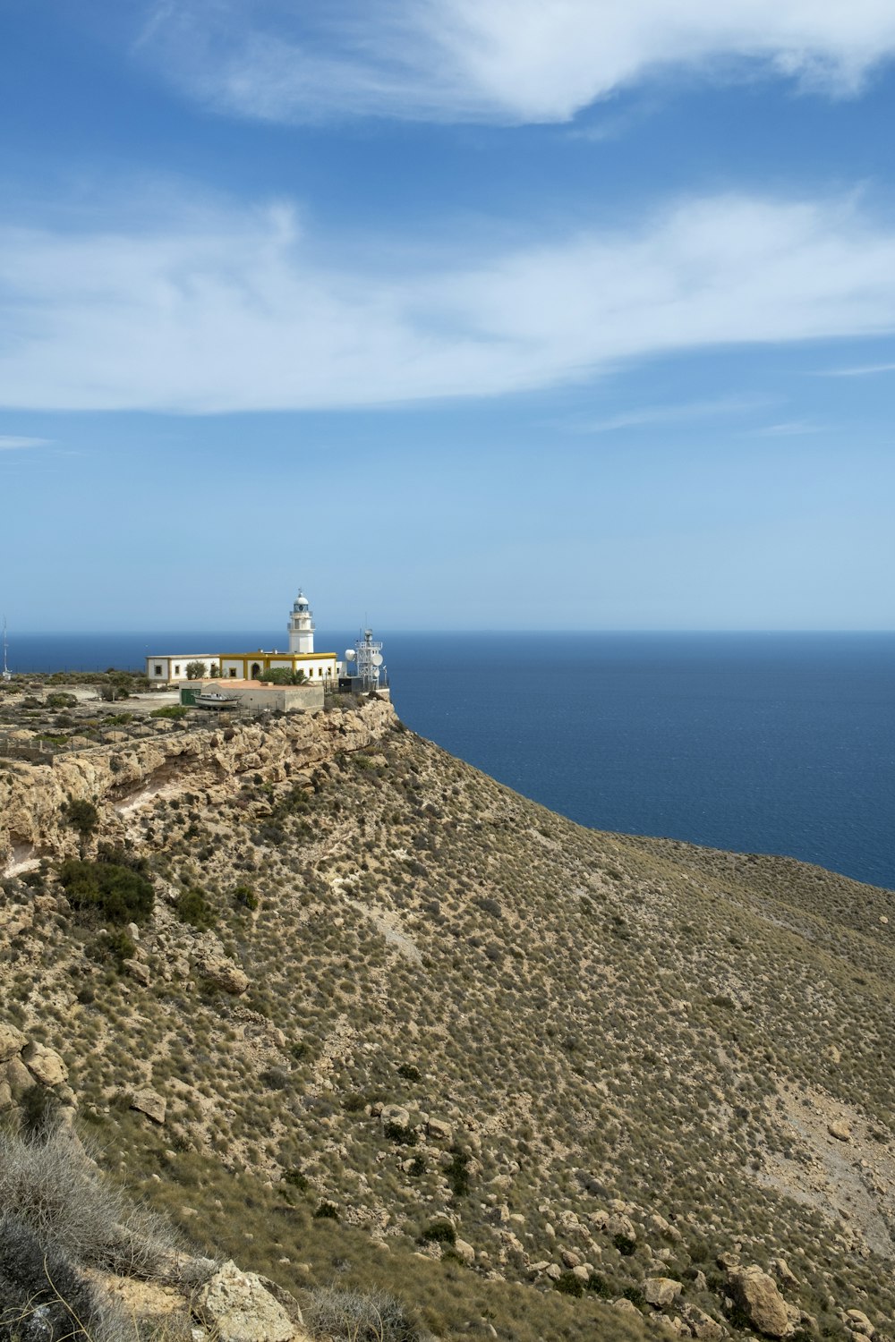 a lighthouse on top of a hill near the ocean