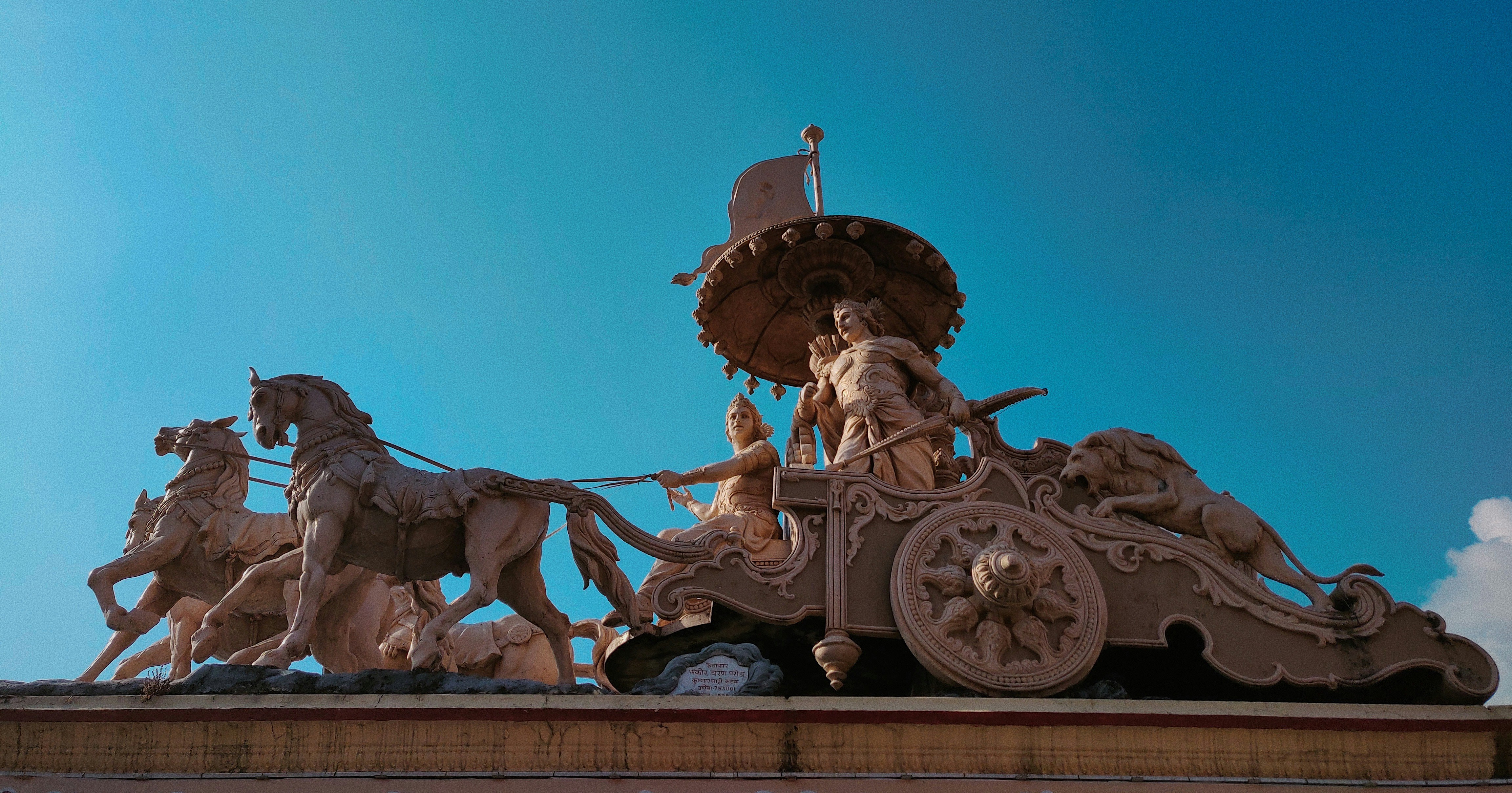 a statue of a man riding a horse drawn carriage