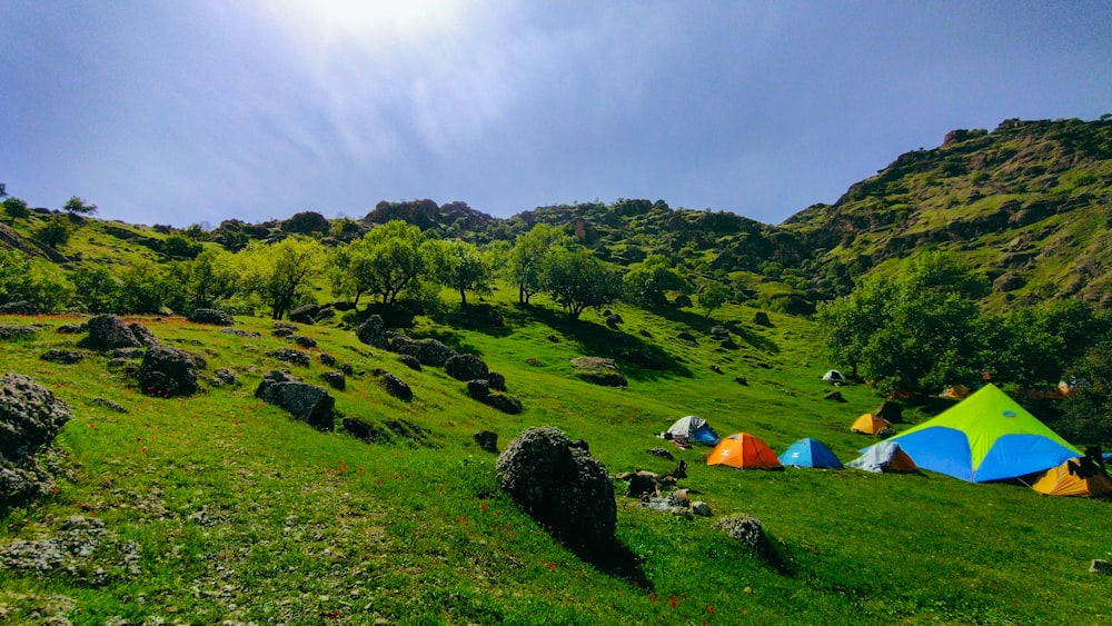 a group of tents set up on a grassy hill