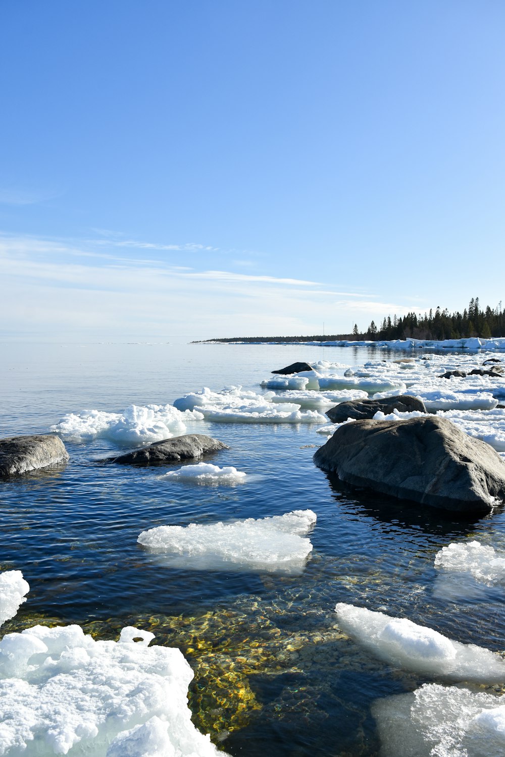 a body of water surrounded by ice covered rocks