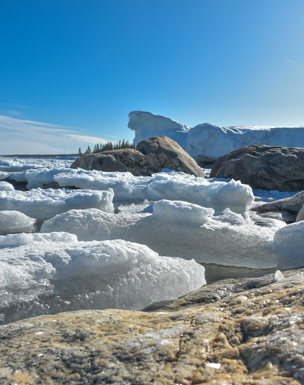 a rocky beach covered in ice and snow