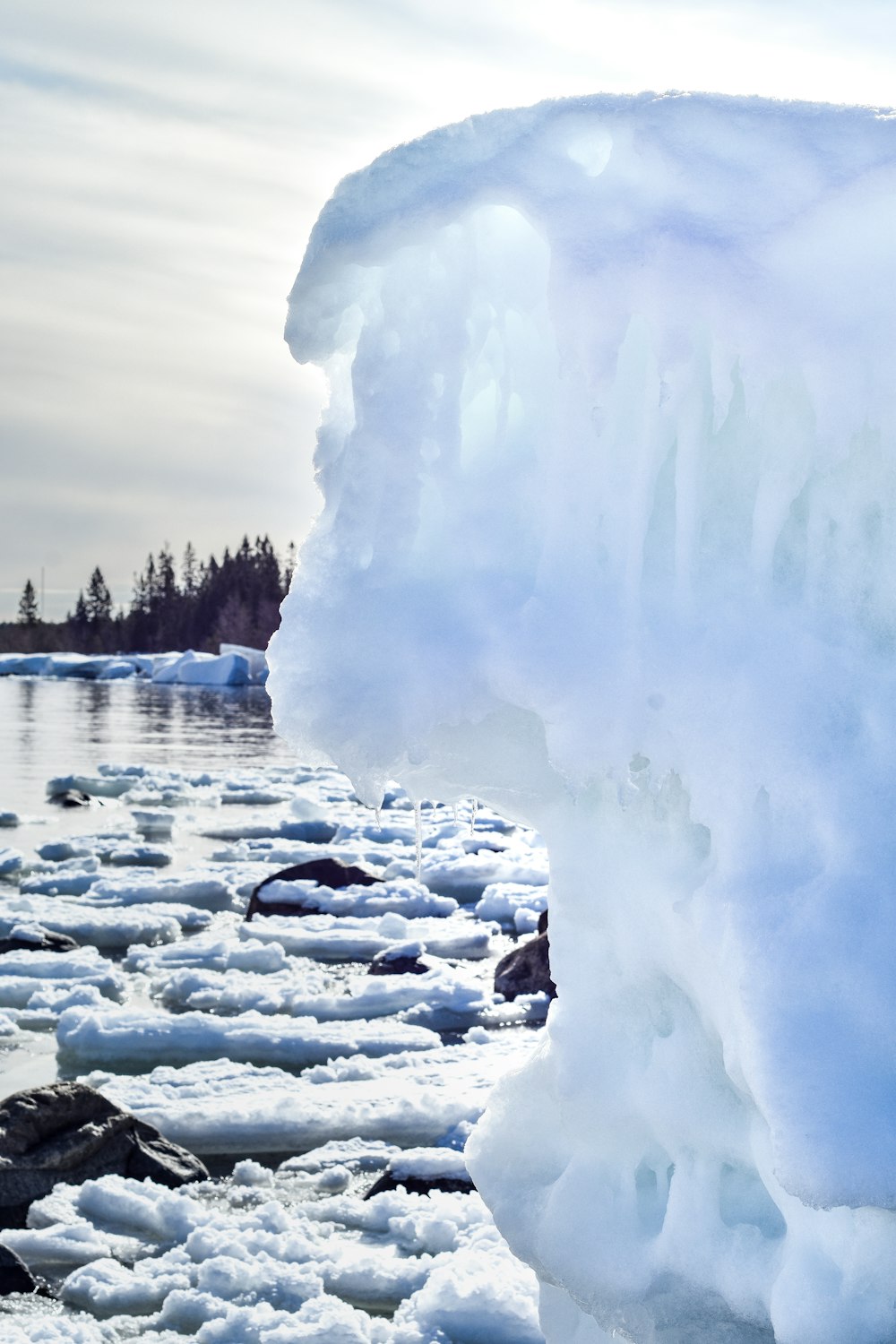 a large chunk of ice on the shore of a lake