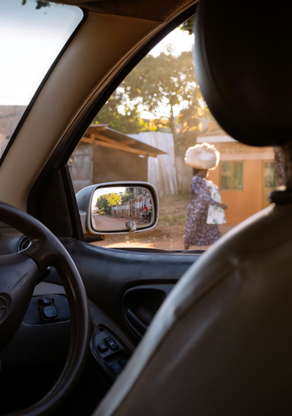 a rear view mirror of a car with a woman in a dress