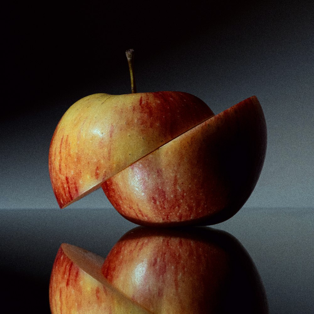 an apple sliced in half with a knife sticking out of it