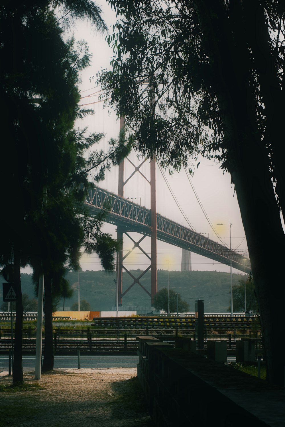 a large bridge spanning over a river next to a forest