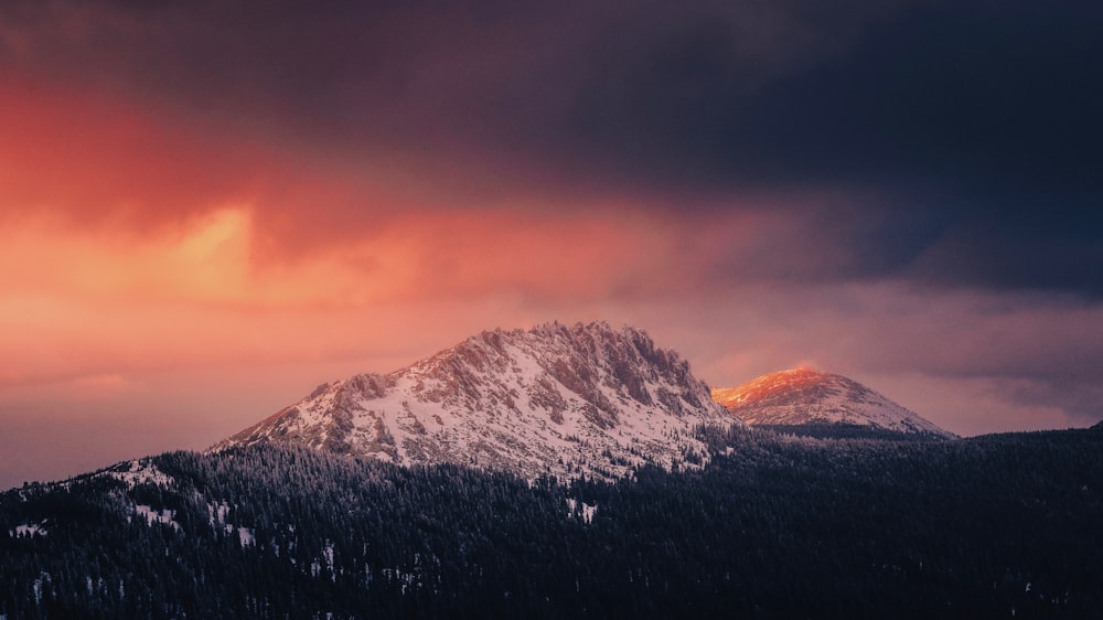 a snow covered mountain under a cloudy sky