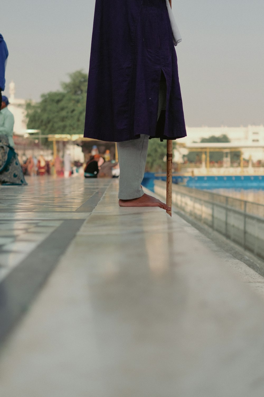 a person with an umbrella walking down a walkway