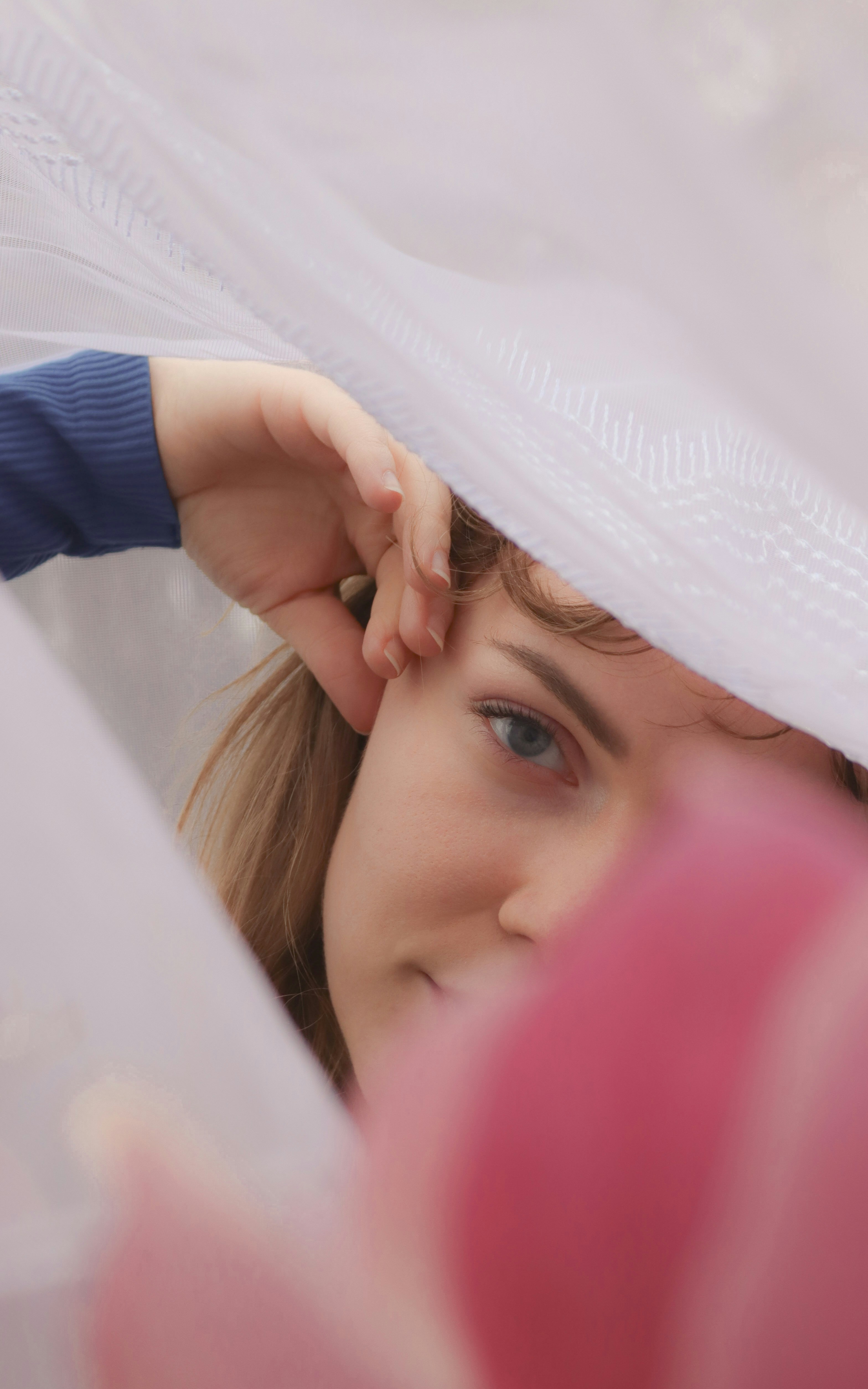 a woman covering her face with a white sheet