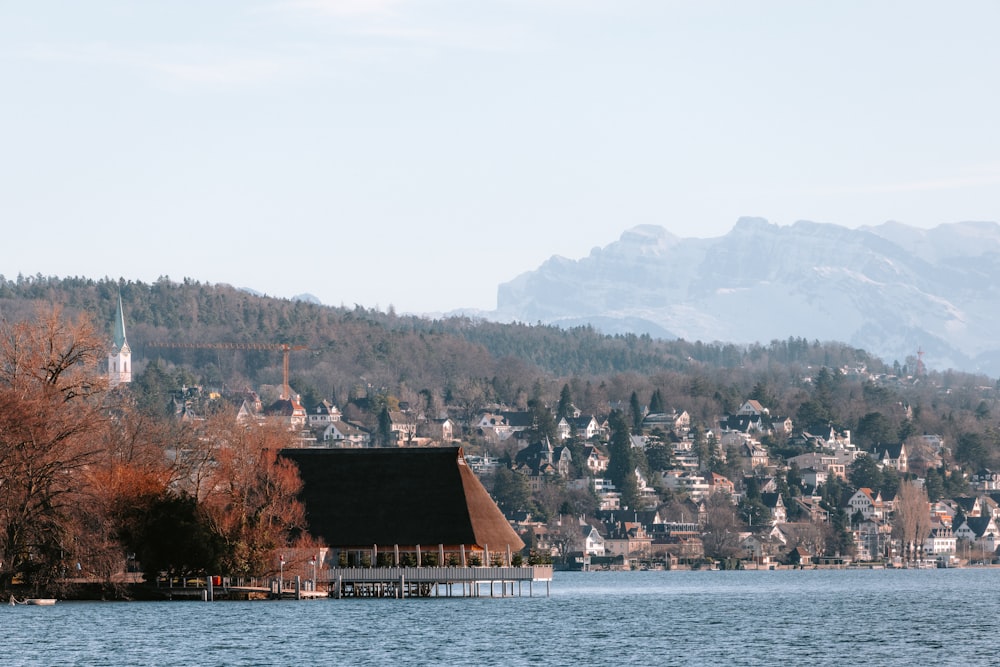 a lake with a house on it and a mountain in the background