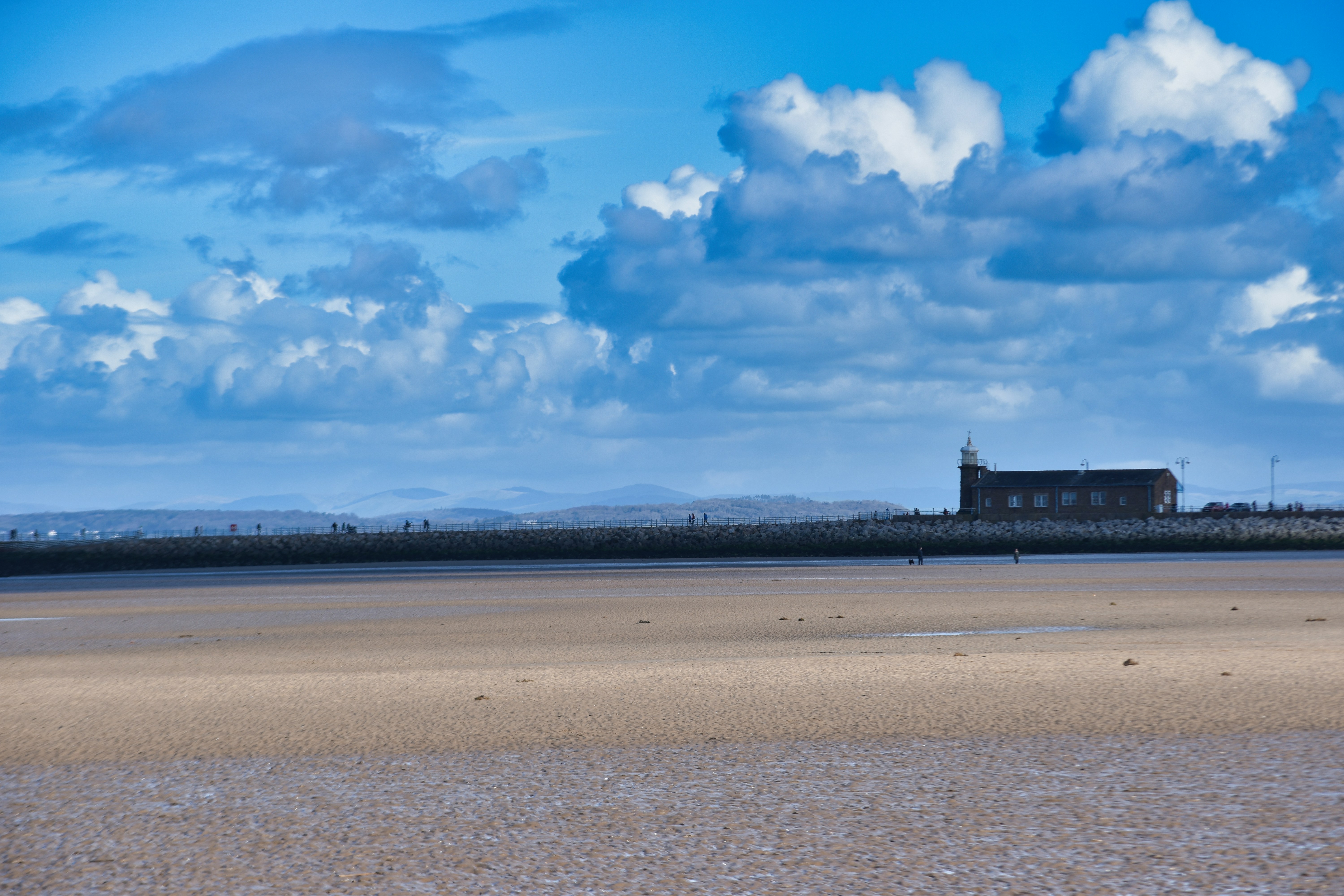 a large body of water sitting under a cloudy blue sky