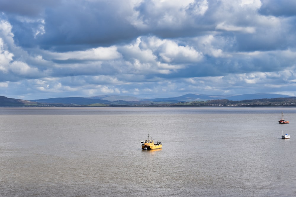 un bateau jaune flottant au-dessus d’une grande étendue d’eau