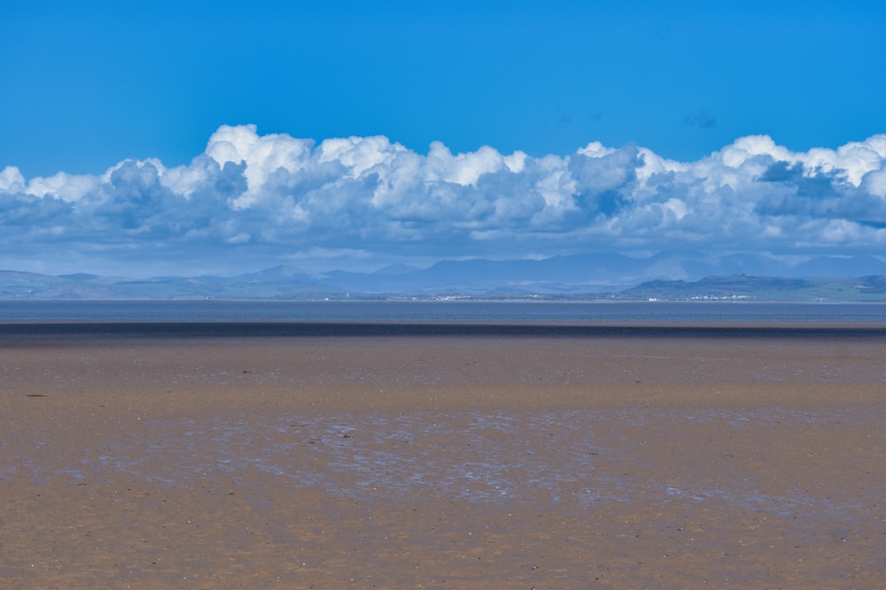 une grande étendue d’eau sous un ciel bleu nuageux