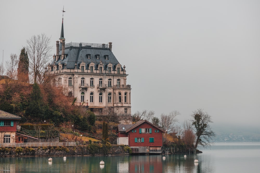 a large building sitting on top of a hill next to a body of water