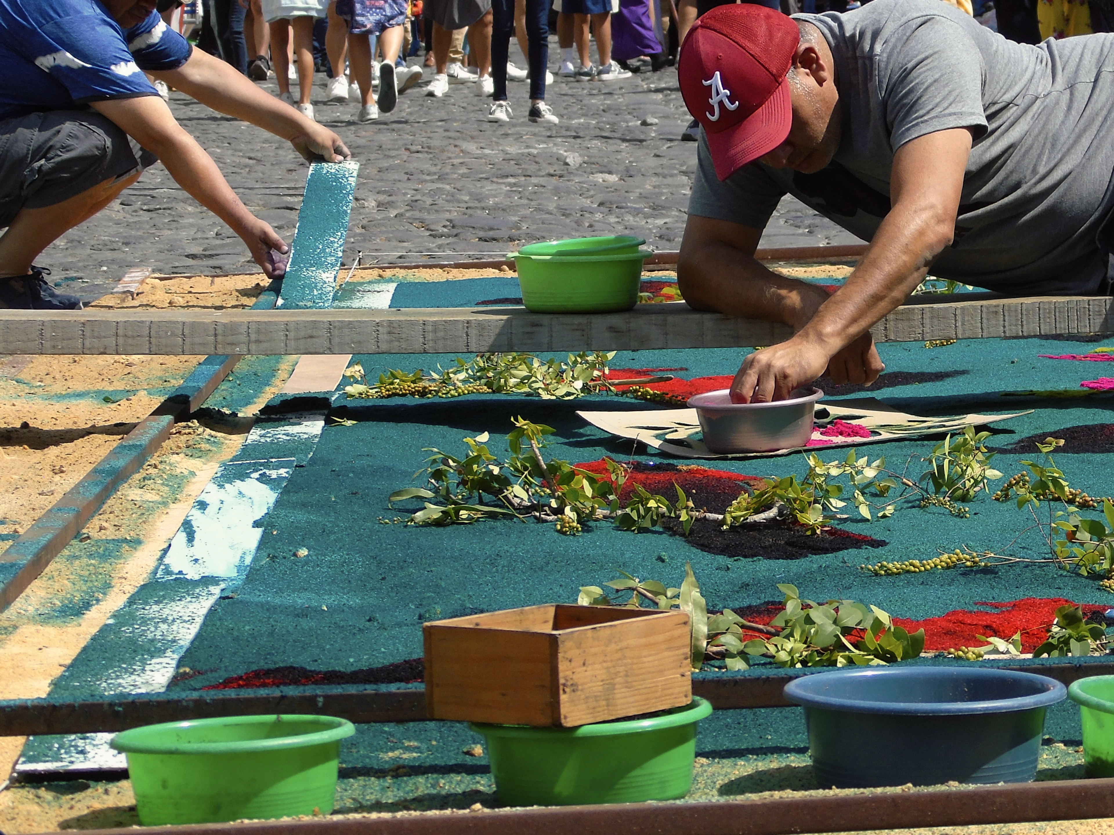 A man making a Holy Week street carpet of dyed sawdust and plants in Antigua, Guatemala