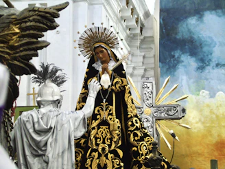 Imagem de Nossa Senhora como foco principal tendo uma estátua de um guerreiro devoto à sua frente