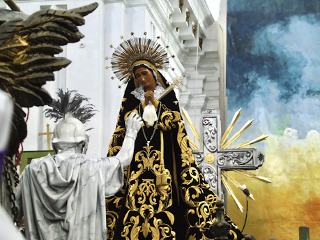 Imagem de Nossa Senhora como foco principal tendo uma estátua de um guerreiro devoto à sua frente