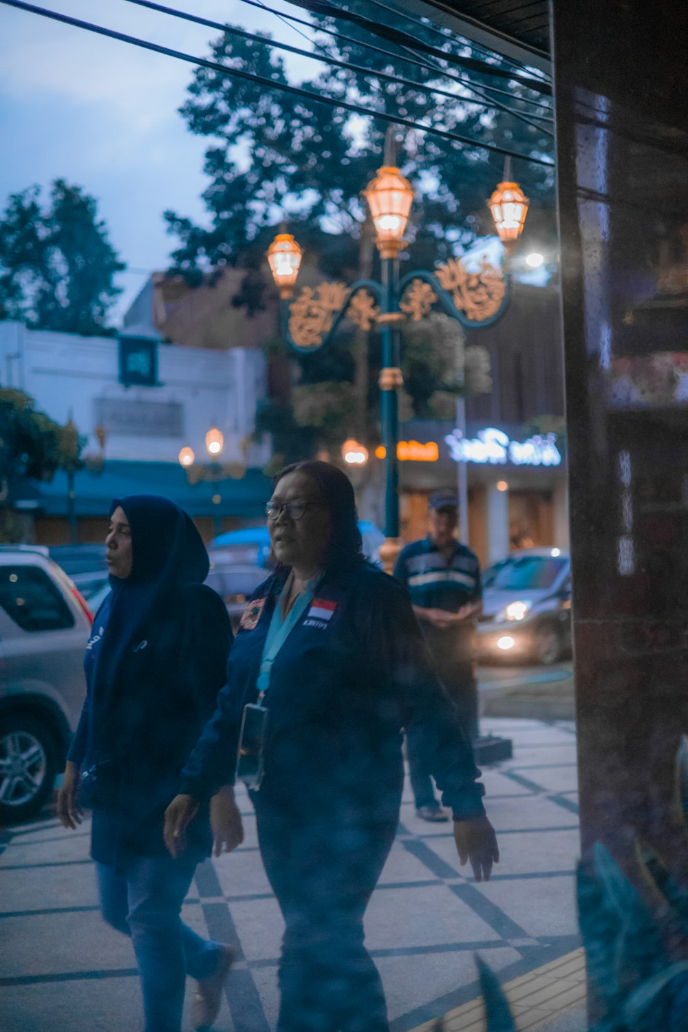 two women walking down a street at night