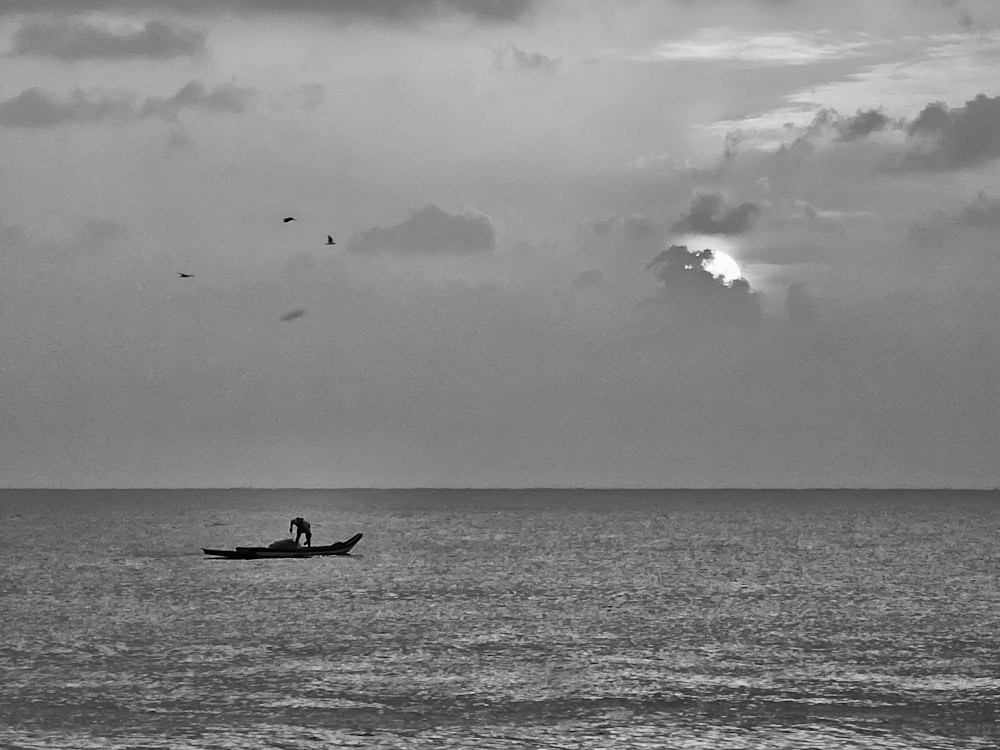 a black and white photo of a person in a boat