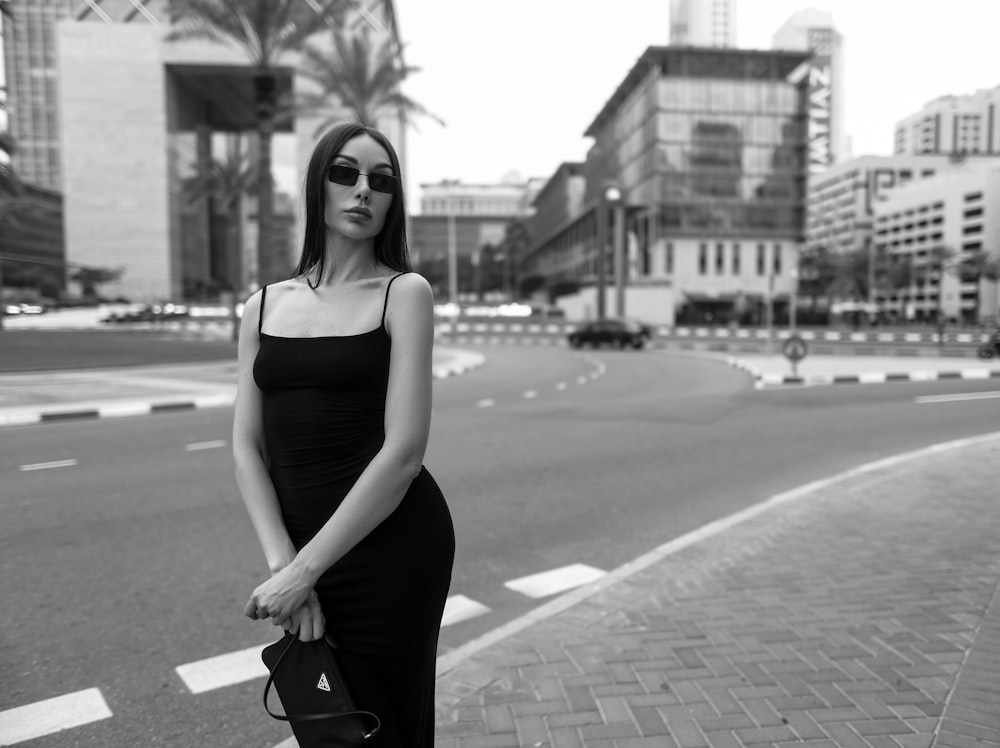 a woman standing on the side of a road