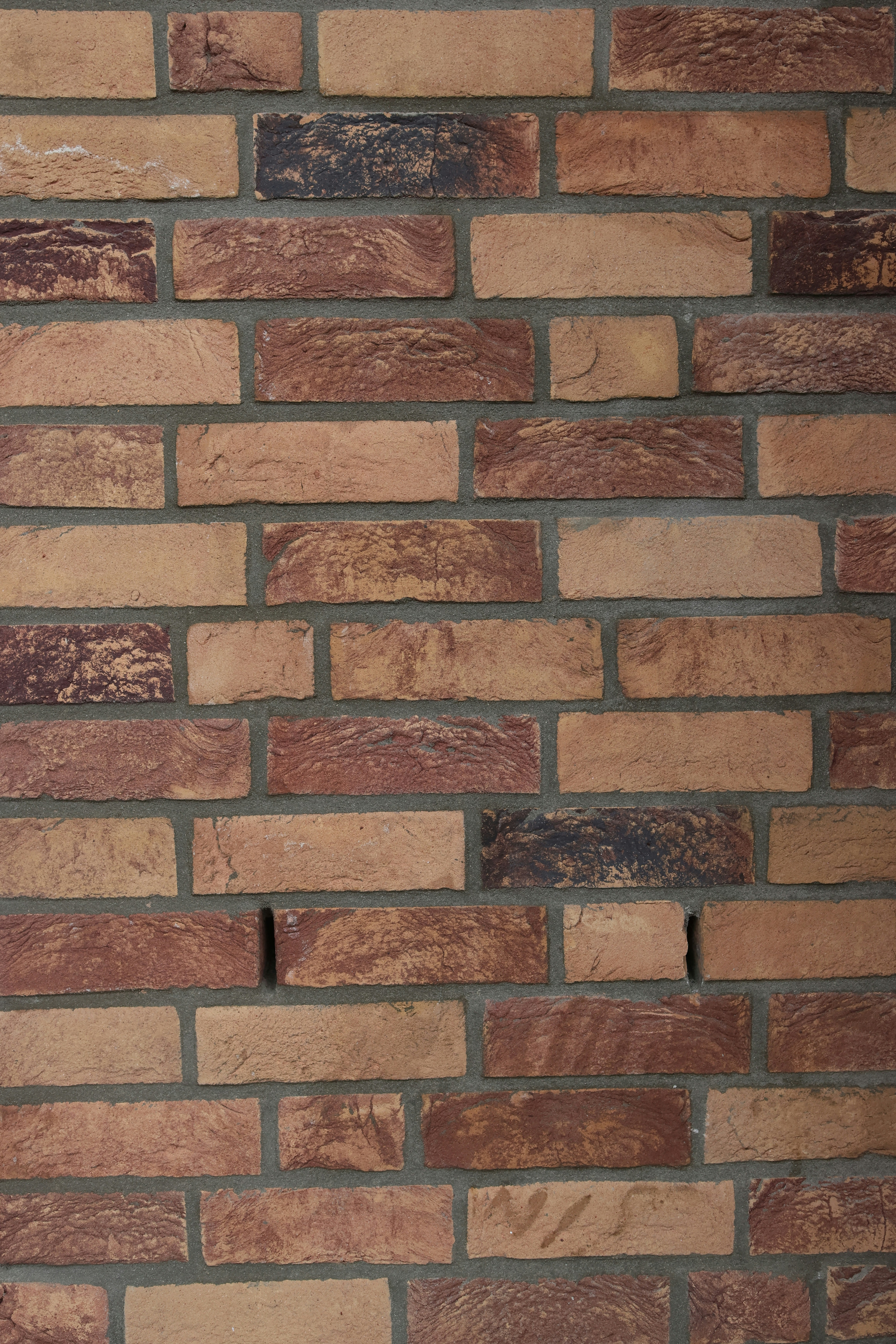 Brick masonry wall installation, warm red tones, professional construction