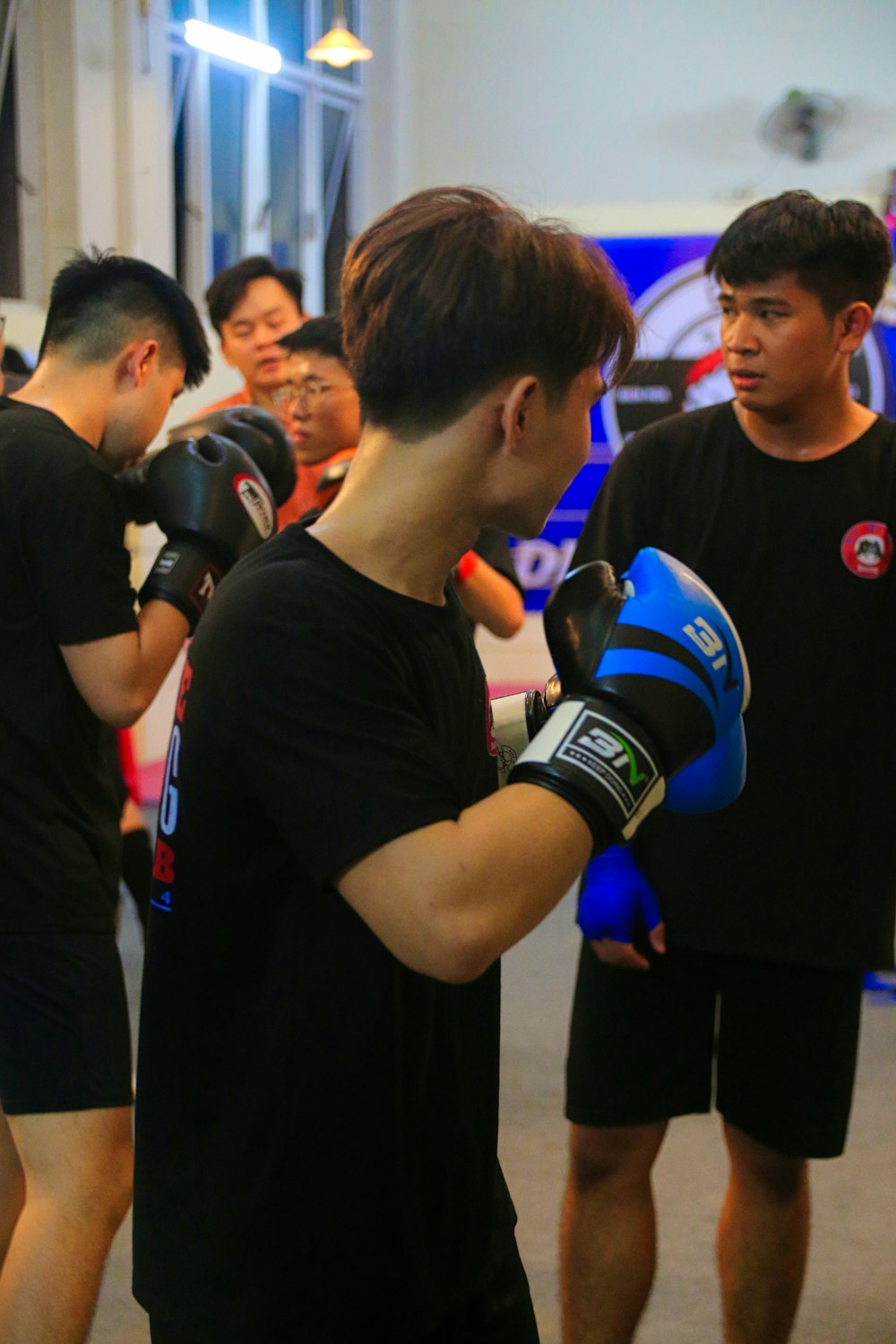 a group of people standing around each other with boxing gloves on