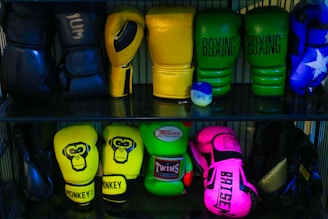 a shelf filled with different colored boxing gloves