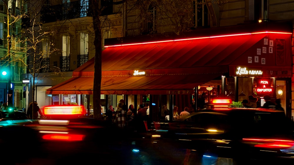 a busy city street at night with cars passing by